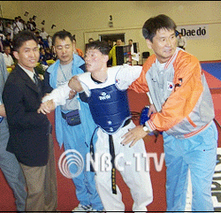 부상을 입었던 이성수가 결승전을 승리로 장식 한 후, 한국선수단의 부축을 받으며 시상대로 향하고 있다.